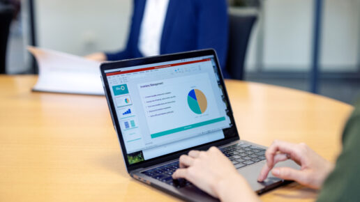 A woman making a business report on her laptop that can show the difference of Prezi vs Google Slides